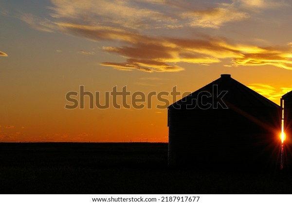 Grain Storage Bins at Sunset. Alberta\
agricultural landscape with grain bins at\
sunset.