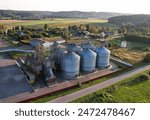 Grain storage Silo at farm, drone view. Wheat flour mill. Elevator for corn storage and grain. Feed Silos Hopper for wheat storage, barley. Wheat flour plant. Grain drying in Steel Silo, aerial view. 