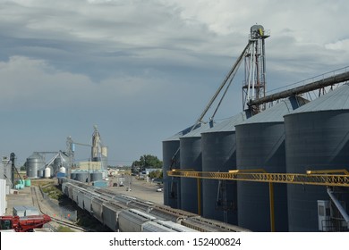 Grain storage silos beside a railroad track in a rural midwestern town.