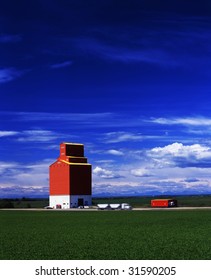 A Grain Truck Pulls Away From A Grain Elevator On The Prairies.