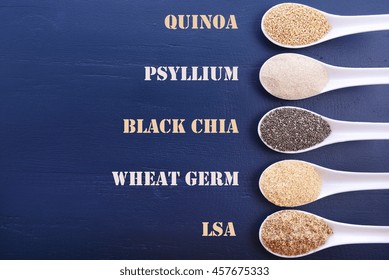 Grains Including, White Grain Quinoa, Psyllium Husk Powder, Black Chia, Wheat Germ, And Ground LSA Mix, In White Measuring Spoons, With Text Labels. 