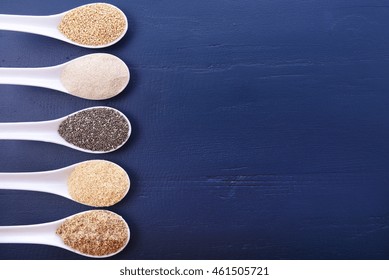 Grains Including, White Grain Quinoa, Psyllium Husk Powder, Black Chia, Wheat Germ, And Ground LSA Mix, On Dark Blue Wood Grain Table, With Copy Space. 