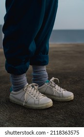 Grainy image of 90s style white shoes and socks with blue baggy pants
