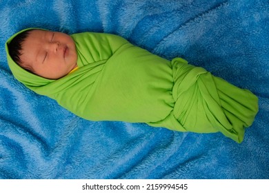 Grainy Look , Noice Of Newborn Indonesian Baby Sleeping Wrapped In A Green Cloth And Sleeping On A Blue Cloth