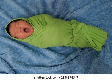 Grainy Look , Noice Of Newborn Indonesian Baby Sleeping Wrapped In A Green Cloth And Sleeping On A Blue Cloth