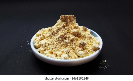 Gram Flour In Bowl Isolated On Black Background