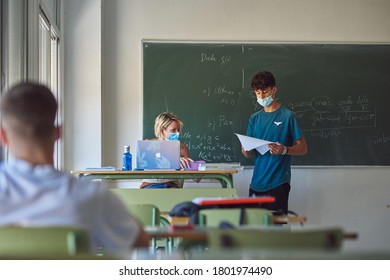 
Granada, Andalusia / Spain;
08/24/2020
Classes in an institute with security measures against coronavirus. Teacher and students with protective mask. New normal. - Shutterstock ID 1801974490