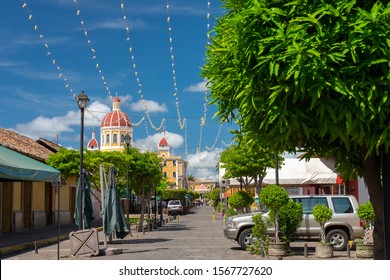 Granada, Nicaragua - Oct 29, 219: Calzada street - pedestrian boulevard with colorful buildings, restaurants and the domes of the Cathedral of Granada. City travel, history and architecture concept.