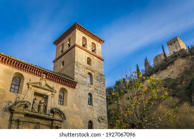 Granada, Spain - December 26th 2019:  Low angle view on San Pedro y San Pablo church and the Alhambra fortification in the city of Granada, Andalusia (Spain)