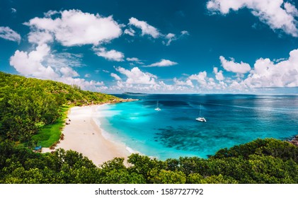 Grand Anse Beach At La Digue Island In Seychelles Aerial Panoramic View. White Sandy Beach With Blue Ocean Lagoon And Catamaran Yacht Moored