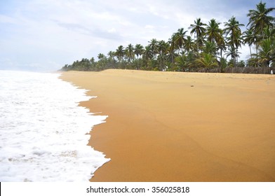 GRAND BASSAM, IVORY COAST, AFRICA. April 2013. Tropical ocean Grand Bassam beach in Cote d'Ivoire, stock photo. Dream of ocean waves, golden sand, palm trees, coconut beach, tropical vacation image. - Shutterstock ID 356025818