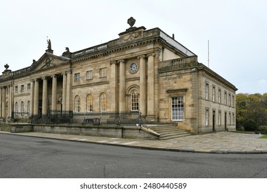 A grand building with double staircases leading to a spacious front porch - Powered by Shutterstock