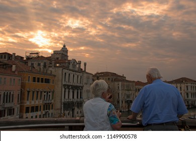 Grand Canal, Venice, Italy - May 17th 2017 - Older Couple Watching At The Beautiful Sunset Sky Standing At The Ponte Della Costituzione Bridge Over Canal Grande In Spring Evening. Editorial.