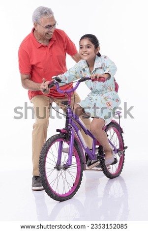 Grand father and grand daughter on bicycle isolated on white background.