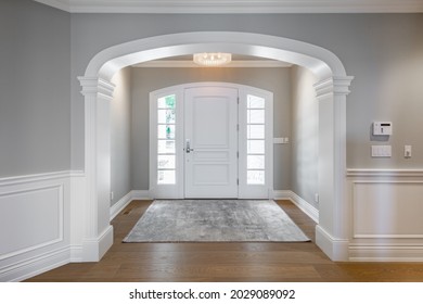 Grand foyer with white doors and elegant staircase and wraught iron