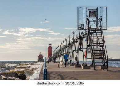 Grand Haven, MI - Oct 20 2021: Evening walks on Pier leading to the historic lighthouse