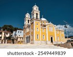 The grand Metropolitan Church of Ypapanti in Kalamata, Greece, with neoclassical architecture, domes, and twin bell towers under a clear sky.