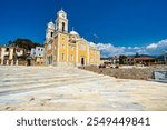 The grand Metropolitan Church of Ypapanti in Kalamata, Greece, with neoclassical architecture, domes, and twin bell towers under a clear sky.