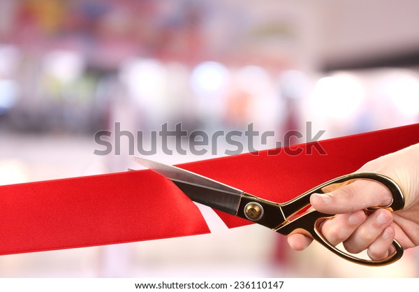 Grand opening, cutting red\
ribbon