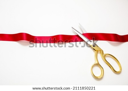 Grand opening, ribbon cut, Gold scissors cutting red satin ribbon isolated on white background. Inaugural invitation, business launch concept, copy space