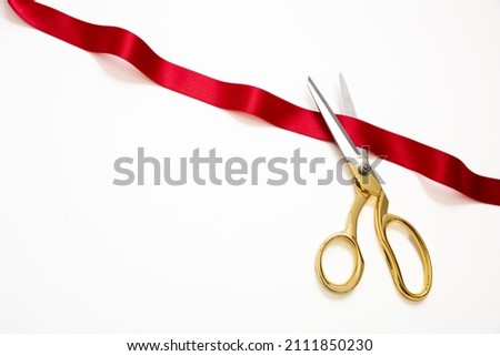 Grand opening, ribbon cut, Gold scissors cutting red satin ribbon isolated on white background. Inaugural invitation, business launch concept, copy space