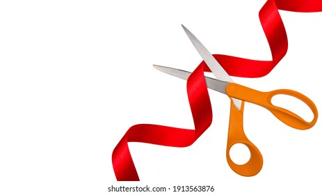 Grand opening. Top view of scissors cutting red silk ribbon against white isolated background with copy space.