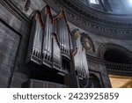 Grand pipe organ with silver, gold, red accents in a majestic interior, under a dark dome with decor, possibly in a Copenhagen or Malmo cathedral or concert hall.