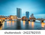 Grand Rapids, Michigan, USA downtown skyline on the Grand River at dusk.