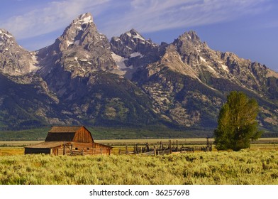 Grand Tetons Mountains With Barn And Fence In Foreground