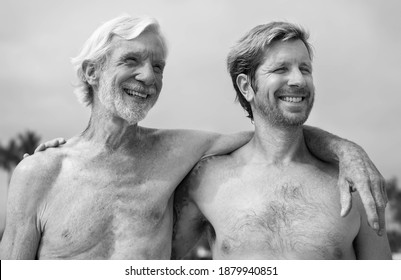 Grandad And Dad With Arms Around Each Other Smiling. Father And Son Love. 