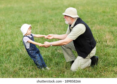 Grandchild And Grandfather Holding Hands And Having Fun Outdoor