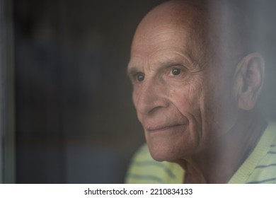 Granddad Looking Through Window Glass Close Side View. Solitude Concept.