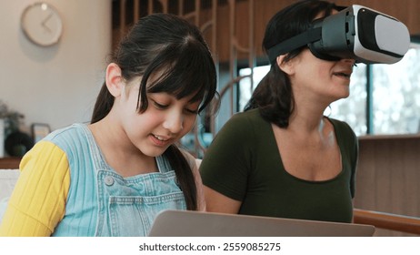 Granddaughter control laptop guide grandmother to dive in metaverse with VR. Senior adapt to technology activity communicate new generation kid cross generation gap strengthen family bond. Divergence. - Powered by Shutterstock