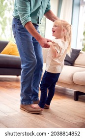 Granddaughter Dancing On Grandfathers Feet In Lounge At Home