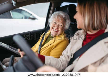 Granddaughter driving her elderly grandmother in the car, taking her to the doctor, shopping or to the bank. Caregiver driving elderly lady to the church, pharmacy.