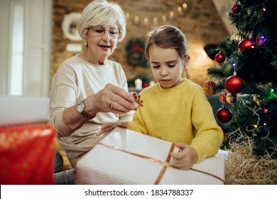 Granddaughter and grandmother preparing for Christmas and wrapping presents at home. - Powered by Shutterstock