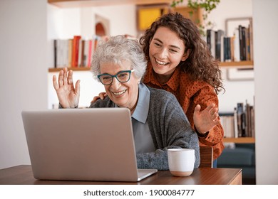 Granddaughter with grandmother waving hand during video call. Senior woman with daughter using laptop during covid-19 lockdown. Old woman sitting with her adult granddaughter making a videocall. - Powered by Shutterstock