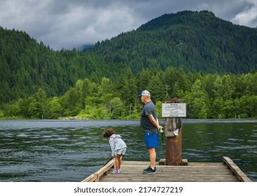 Granddaughter And Her Grandfather Playing On Lake In Park. Grandparent With Grandchild Enjoying Time Together By The Lake. Travel Photo, Selective Focus-June 29,2022-Pitt Lake BC Canada.