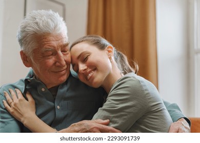 Granddaughter hugging her grandfather in their home. - Powered by Shutterstock