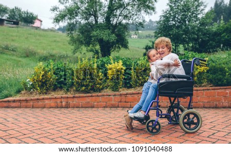 Granddaughter hugging grandmother in wheelchair