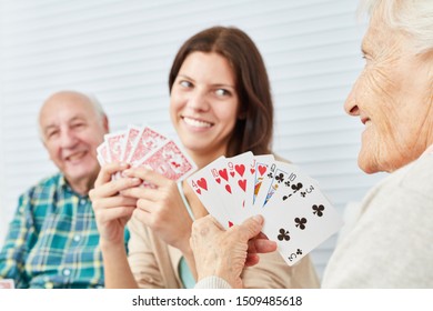 Granddaughter plays cards together with grandparents in nursing home or at home - Powered by Shutterstock