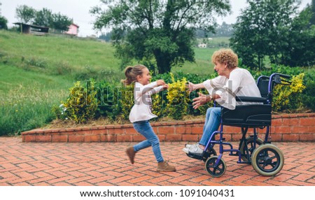 Similar – Granddaughter hugging grandmother in wheelchair