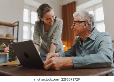 Granddaughter showing something to her grandfather on laptop. - Powered by Shutterstock