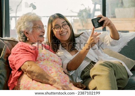 The granddaughter takes a self-portrait with her grandmother for her social networks.