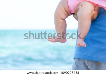 Grandfather and baby feet at the beach.