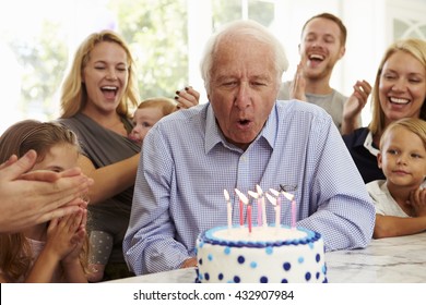 Grandfather Blows Out Birthday Cake Candles At Family Party - Powered by Shutterstock