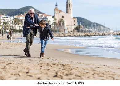 Grandfather Chasing Her Grandson On The Beach