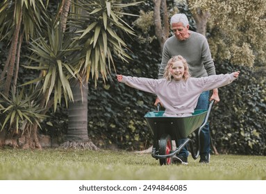 Grandfather, child and happy in wheelbarrow outdoor for transport ride, fantasy play and physical exercise. Smile, senior man and girl with cart for family bonding, safety and balance development - Powered by Shutterstock