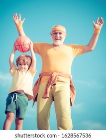 Grandfather And Child Training Together. Be In Motion. Senior Man And Child In Family Health Club. Senior Man And Child Exercising On Blue Sky