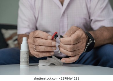 Grandfather cleaning his hearing aids so he can listen. - Powered by Shutterstock